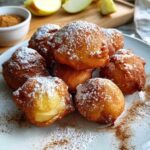 Apfelküchle, die in einer Pfanne mit heißem Öl goldbraun frittieren.