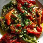 Rode en groene paprika's die onder een hete ovengrill liggen te blakeren.