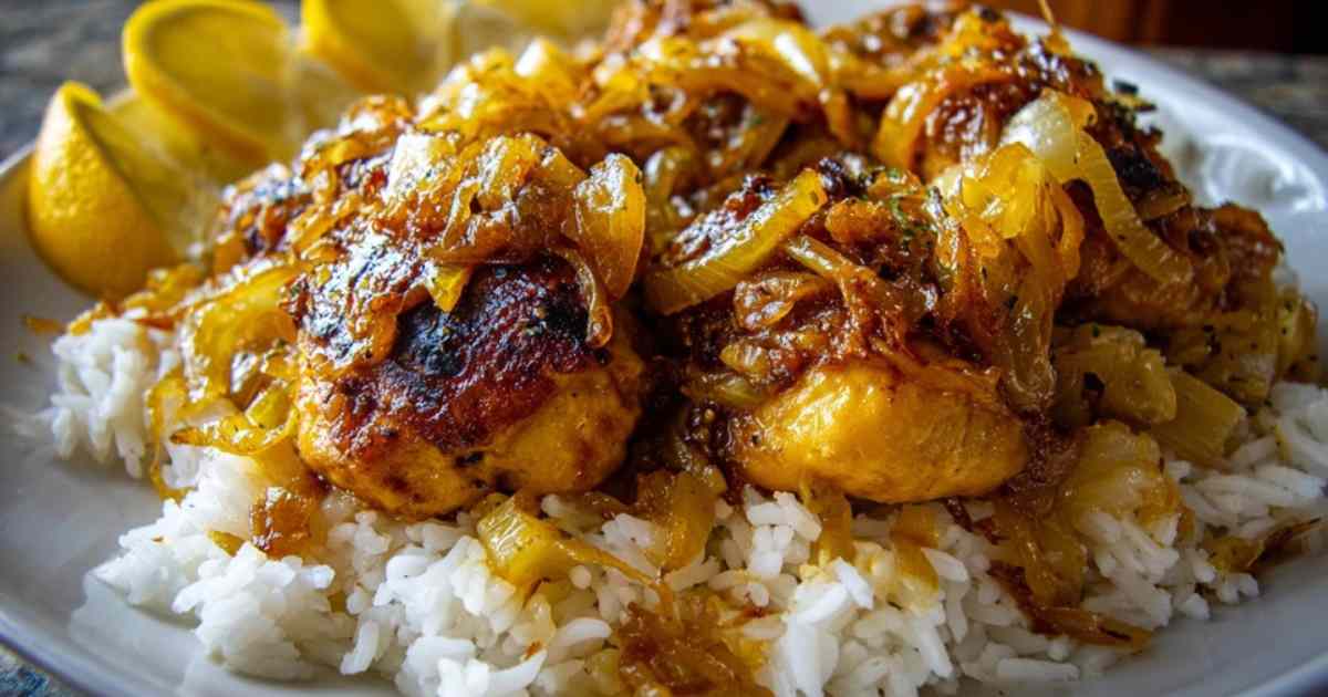 Een bord met Senegalese Poulet Yassa, geserveerd op witte rijst en gegarneerd met verse peterselie