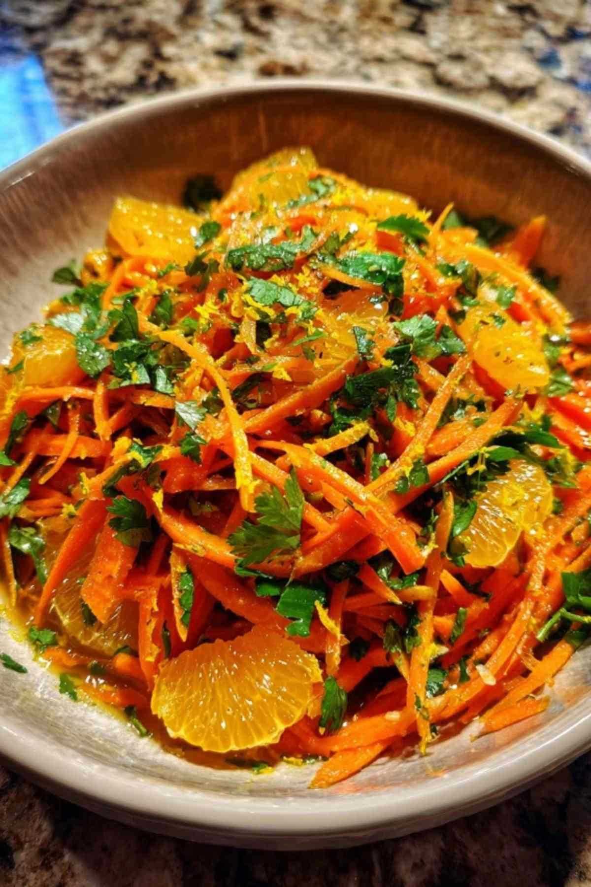 Ingrediënten voor de wortelsalade: verse wortelen, sinaasappels, olijfolie, komijn en koriander.