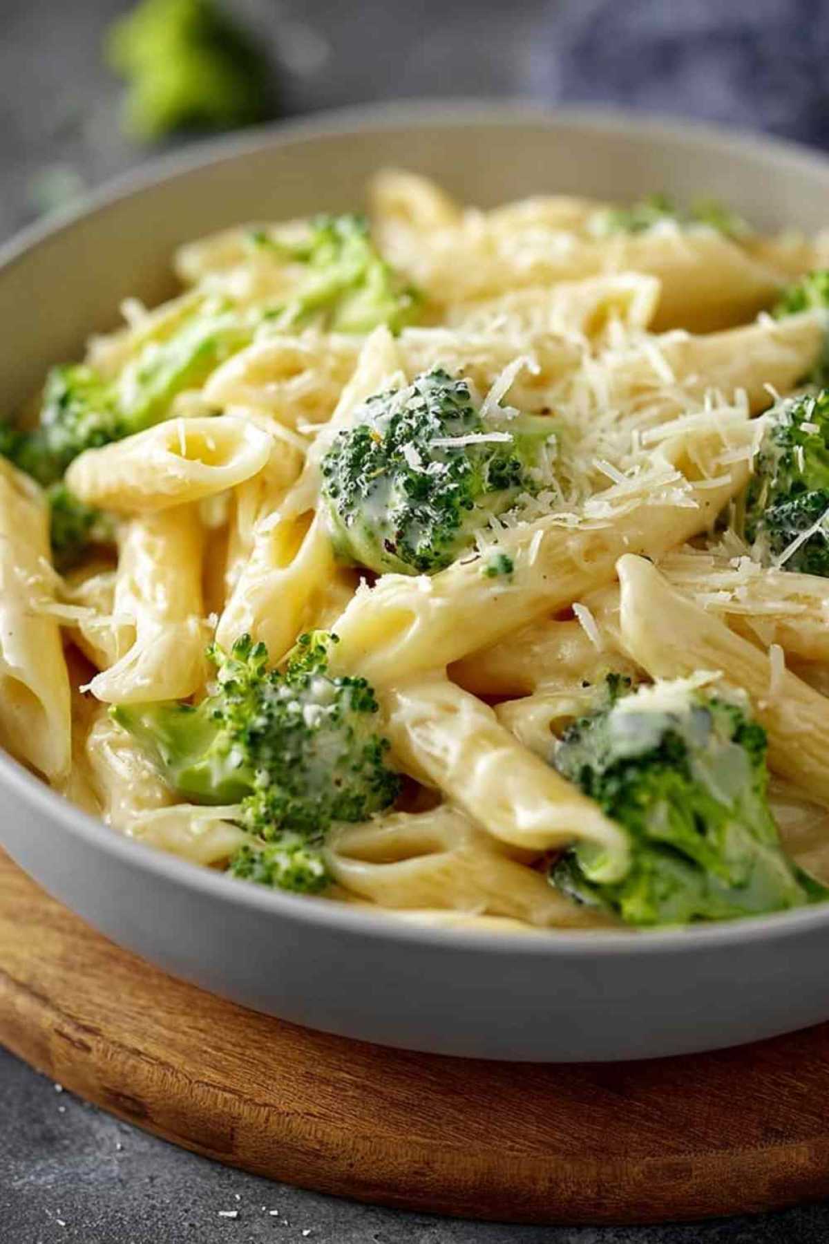 Brokkoli-Käse-Nudeln mit cremiger Käsesauce und frischem Brokkoli auf weißem Teller
