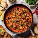 Cremige Zucchini-Bohnenpfanne mit Erdnussbutter in schwarzer Pfanne mit frischer Petersilie garniert