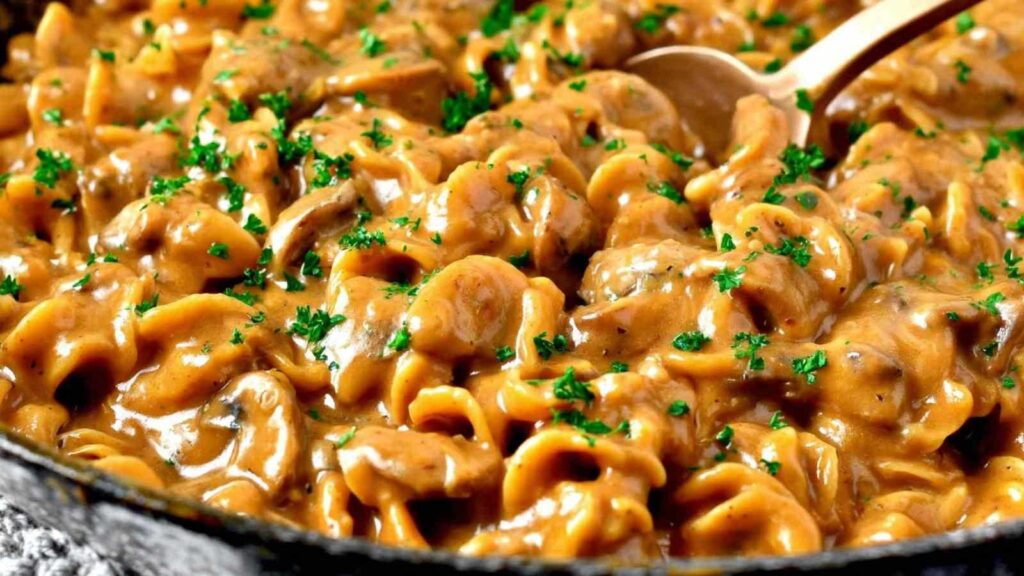 French Onion Pasta mit geschmolzenem Käse und karamellisierten Zwiebeln im großen Topf