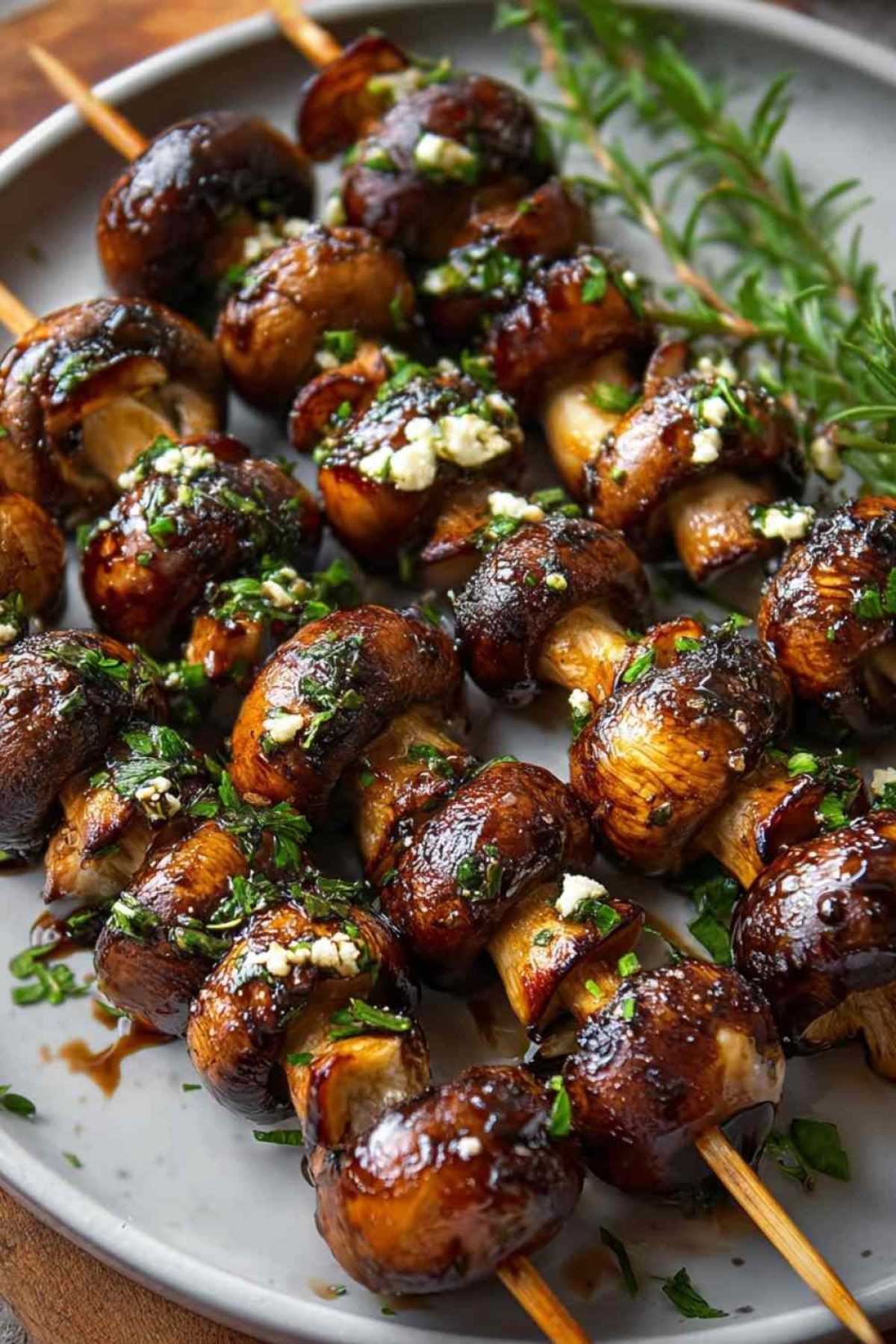 Gegrillte Champignon-Spieße auf dem Grillrost mit goldbrauner Farbe und Grillstreifen