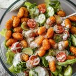 Knuspriger Gnocchi-Salat mit goldbraunen Gnocchi auf frischem Eisbergsalat mit Joghurt-Dressing