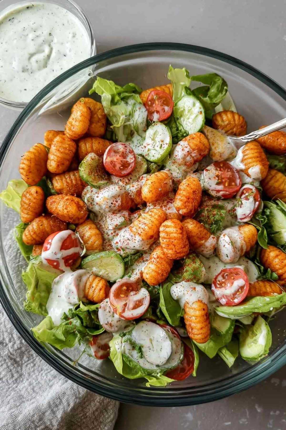 Knuspriger Gnocchi-Salat mit goldbraunen Gnocchi auf frischem Eisbergsalat mit Joghurt-Dressing