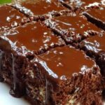 Himmel im Mund Kuchen mit glänzender Schokoladenglasur auf weißem Teller servierfertig