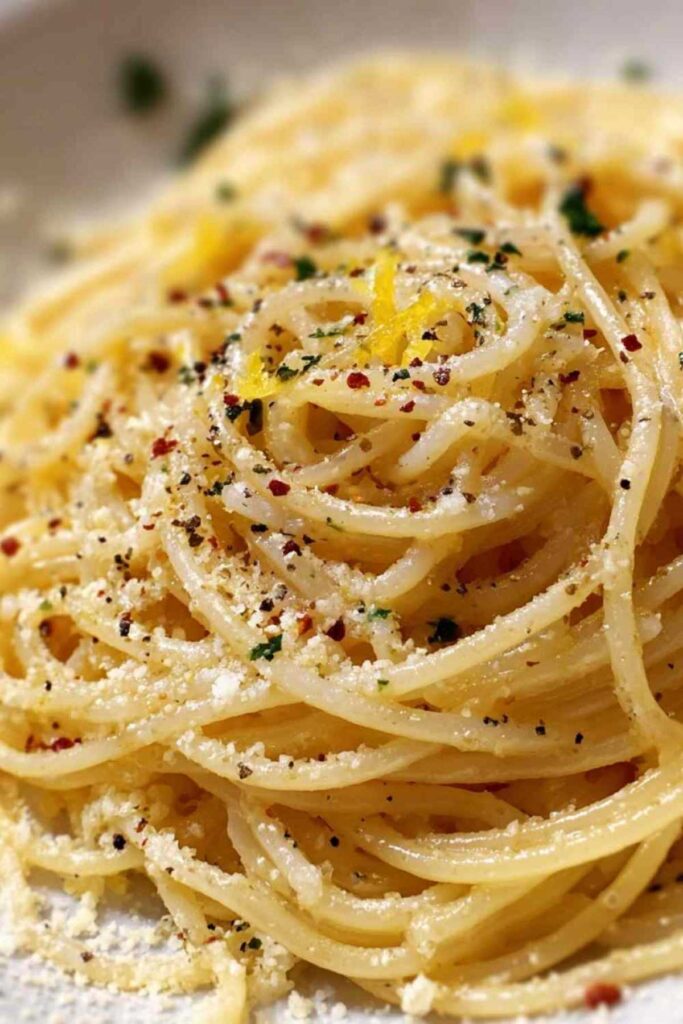 Midnight Pasta mit Knoblauch, Olivenöl und frischer Petersilie serviert auf weißem Teller