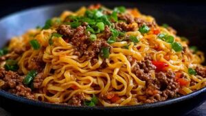 Mongolische Hackfleisch Nudeln mit Sesamsamen in schwarzer Pfanne serviert