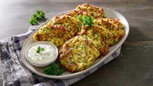 Goldbraune Zucchinipuffer auf Backblech mit Backpapier frisch aus dem Ofen