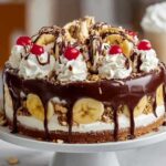 Banana Split Torte auf eleganter Tortenplatte mit Schokoladensoße und Zebra-Röllchen dekoriert