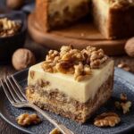 Friss-dich-dumm-Kuchen mit Walnüssen geschnitten zeigt drei Schichten Mürbeteig Pudding und Walnüsse
