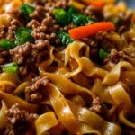 Mongolische Hackfleisch Nudeln mit Sesamsamen in schwarzer Pfanne serviert