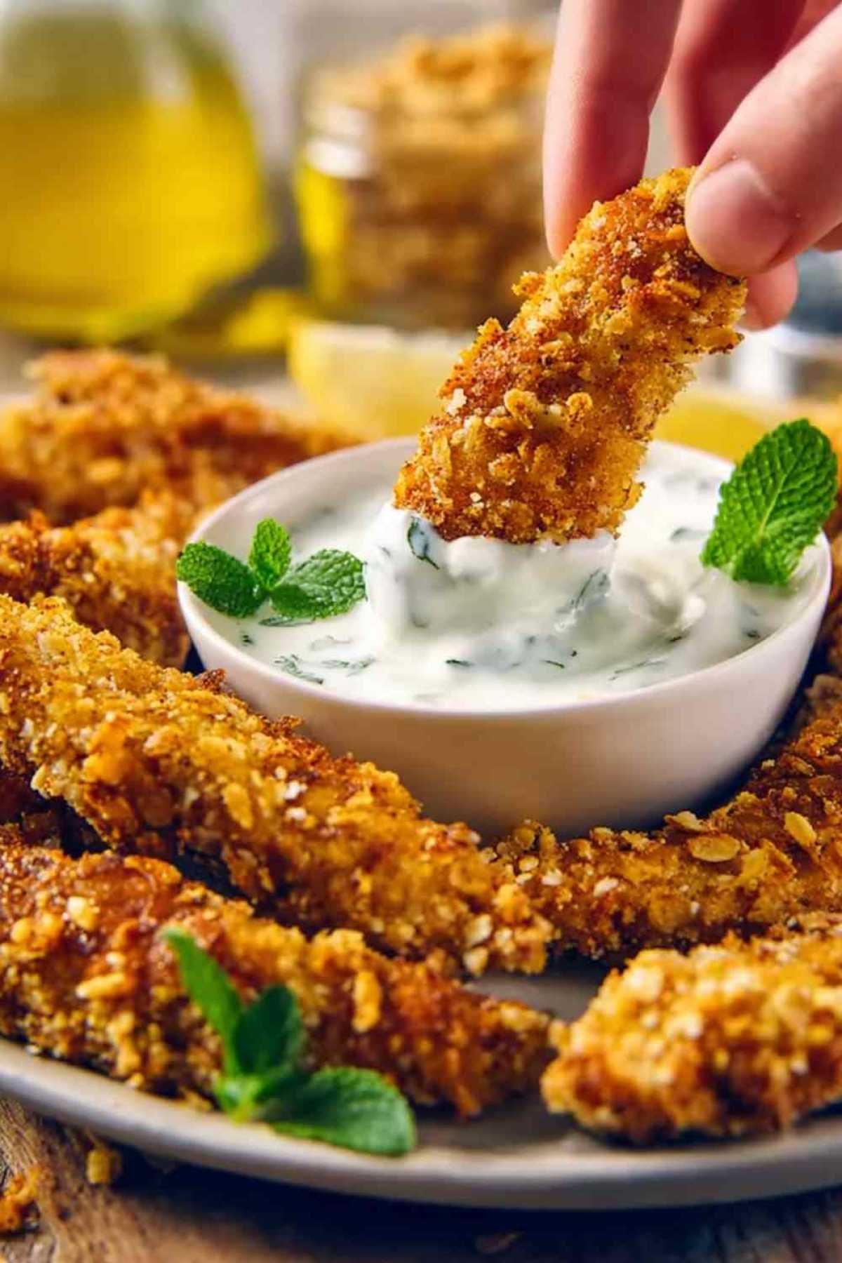 Knusprige Low Carb Zucchini Pommes serviert mit cremigem Kräuterdip auf weißem Teller