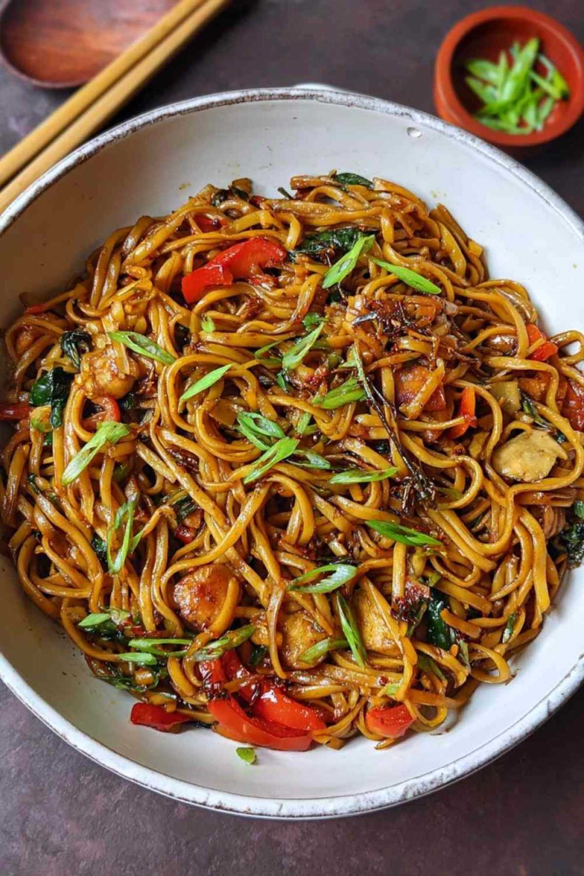 Gebratene Asia Nudeln mit buntem Gemüse in der Pfanne beim Braten