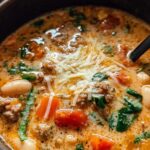Herzhafte toskanische Suppe mit Kichererbsen und Spinat in rustikaler Schüssel serviert