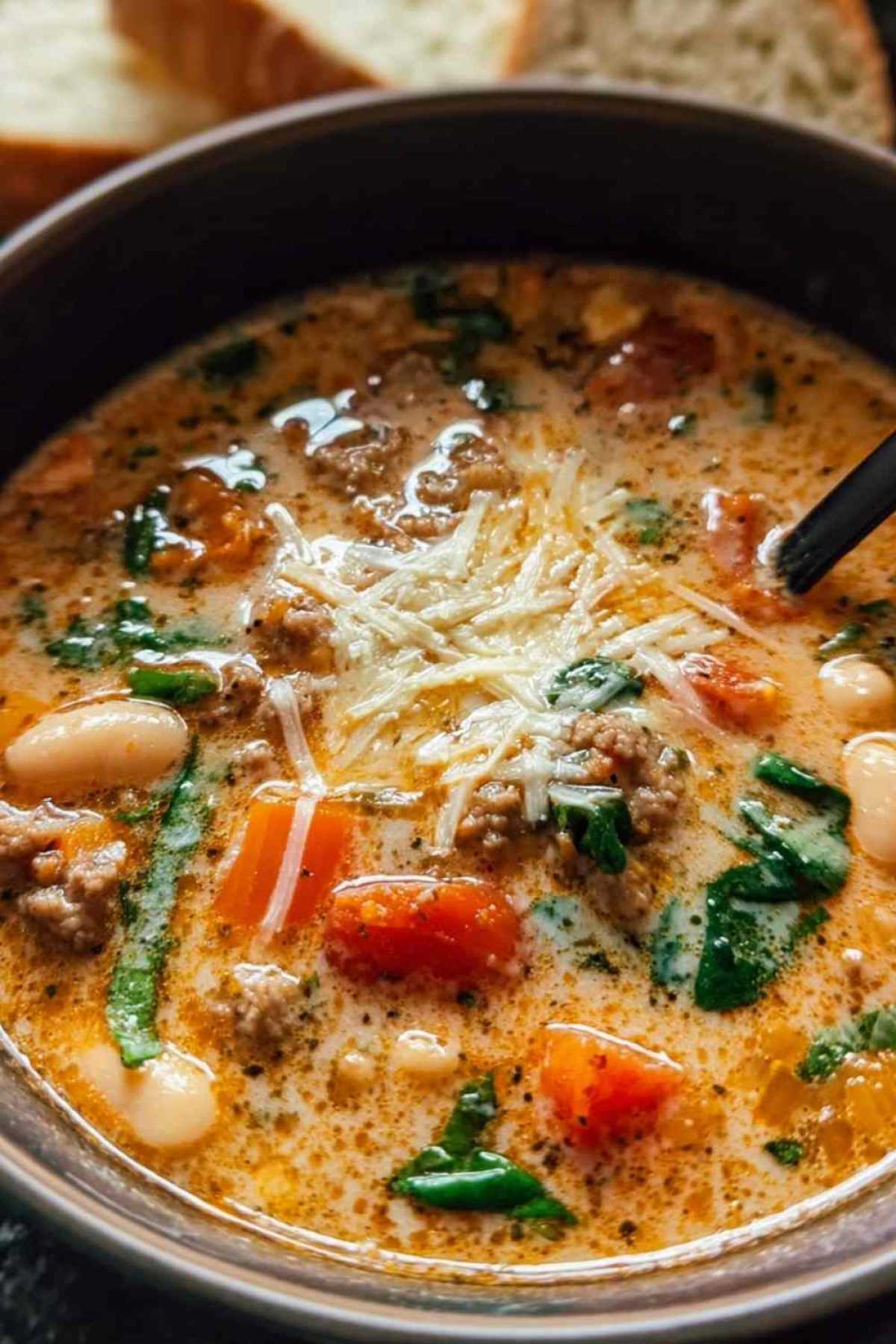 Herzhafte toskanische Suppe mit Kichererbsen und Spinat in rustikaler Schüssel serviert