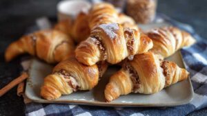 Goldbraune Nusshörnchen frisch aus dem Ofen auf Backpapier mit glänzender Oberfläche