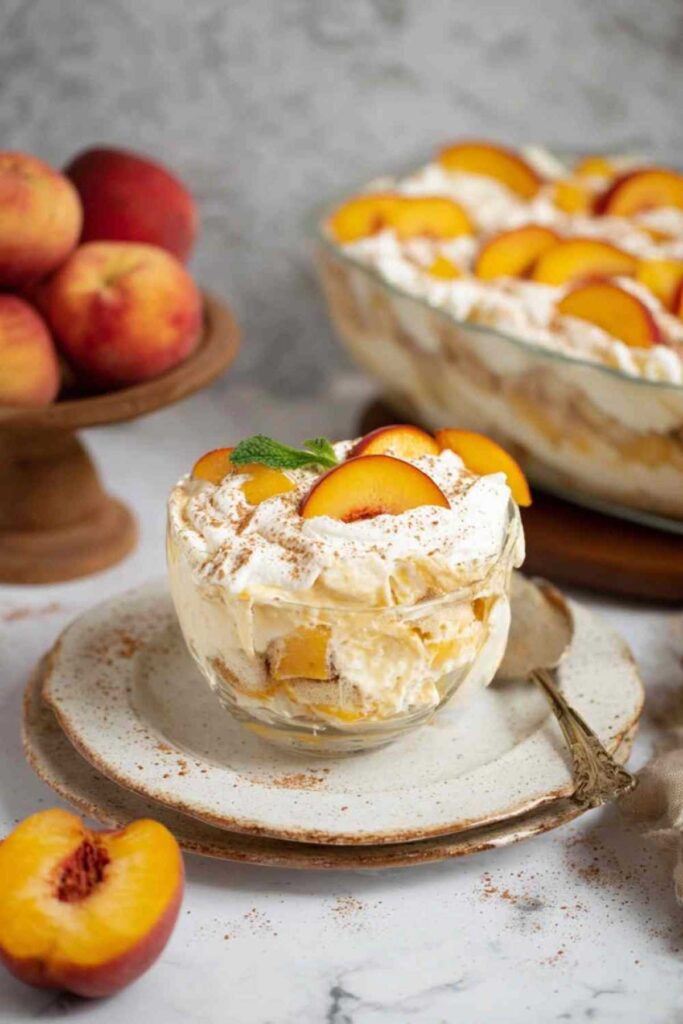 Pfirsich Tiramisu in Glasschüssel mit gerösteten Mandelblättchen und frischer Minze garniert