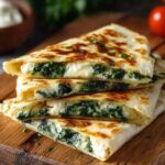 Goldbraune Spinat-Feta-Quesadillas in Viertel geschnitten auf rustikalem Holzbrett serviert