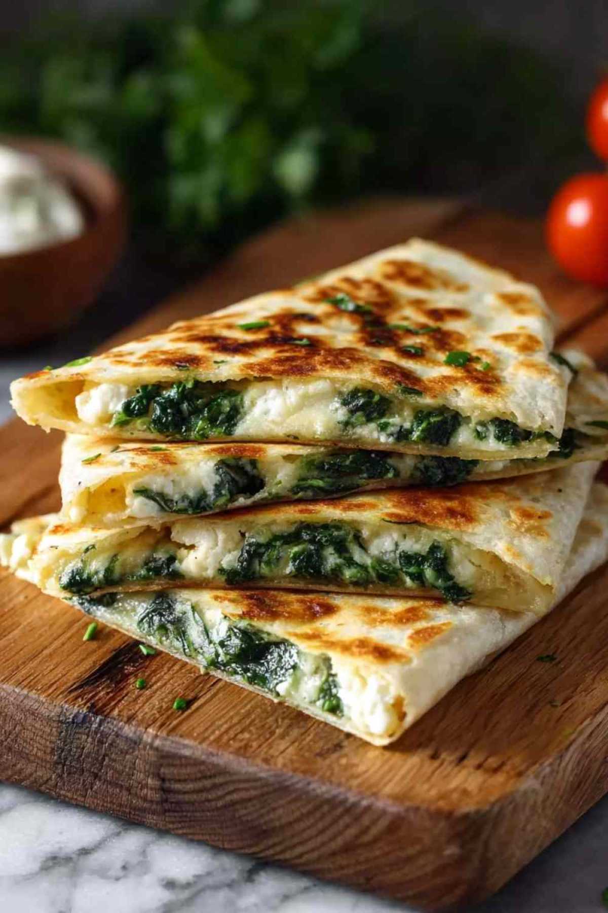 Goldbraune Spinat-Feta-Quesadillas in Viertel geschnitten auf rustikalem Holzbrett serviert