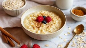 Vanillepudding Oats in weißer Schüssel mit frischen Beeren als Topping