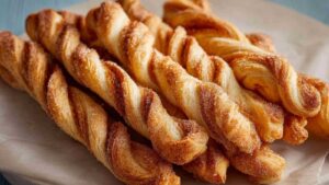 Zimt Zucker Twists aus Blätterteig goldbraun gebacken auf Backpapier