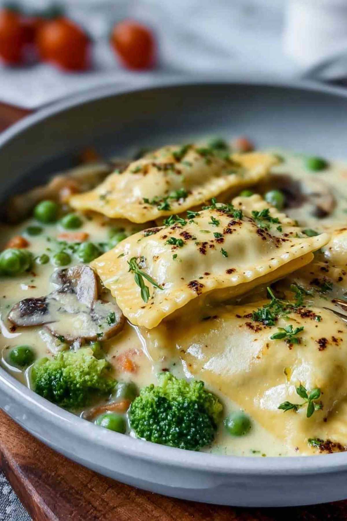 Maultaschen in cremiger Käse-Sahne-Soße in schwarzer Pfanne mit frischer Petersilie garniert