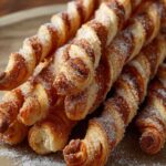Goldbraune Zimt-Zucker-Stangen aus Blätterteig frisch vom Backblech mit karamellisierter Oberfläche