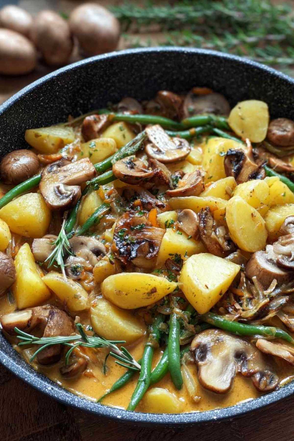 Cremige Kartoffel-Pilz-Pfanne mit Bohnen in gusseiserner Pfanne mit goldbrauner Kruste