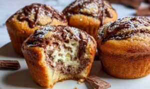 Frisch gebackene Kinder-Bueno-Muffins mit goldbrauner Oberfläche auf einem Kuchengitter