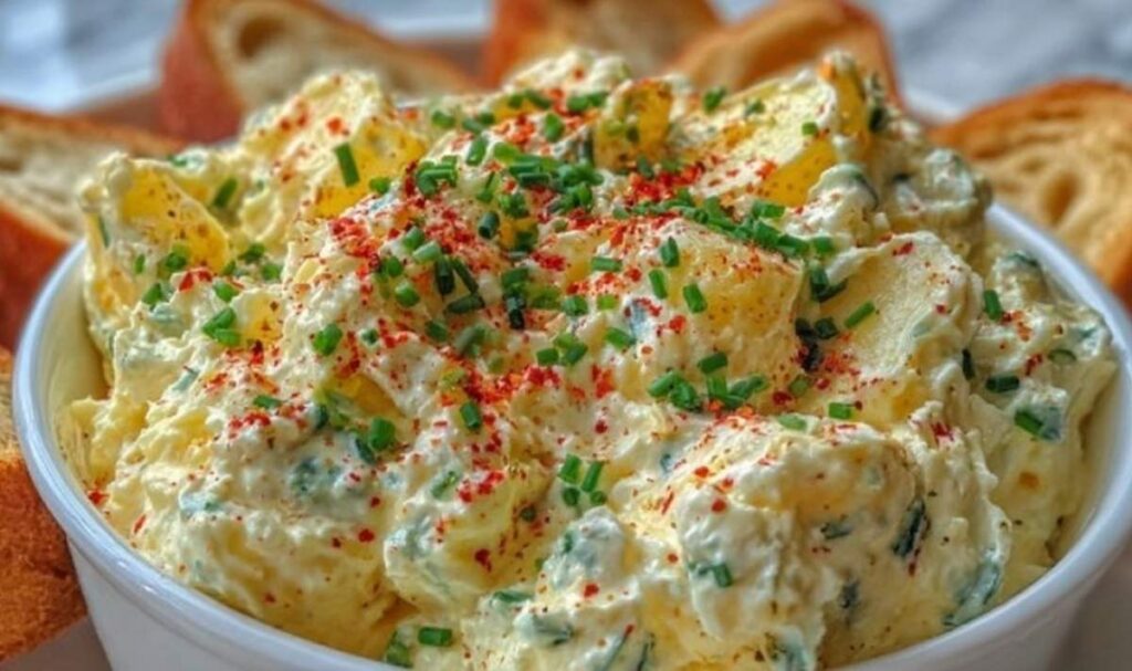 Bayrischer Partykäseaufstrich mit Emmentaler und frischen Kräutern in rustikaler Schüssel serviert