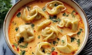 Cremige Thai-Knödel-Suppe in weißer Schüssel mit Koriander garniert und Limettenspalten