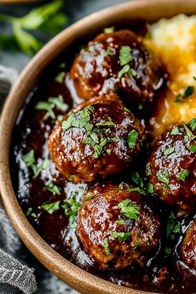 Geschmorte Rinder-Fleischbällchen auf cremigem Kartoffelpüree mit reichhaltiger Soße