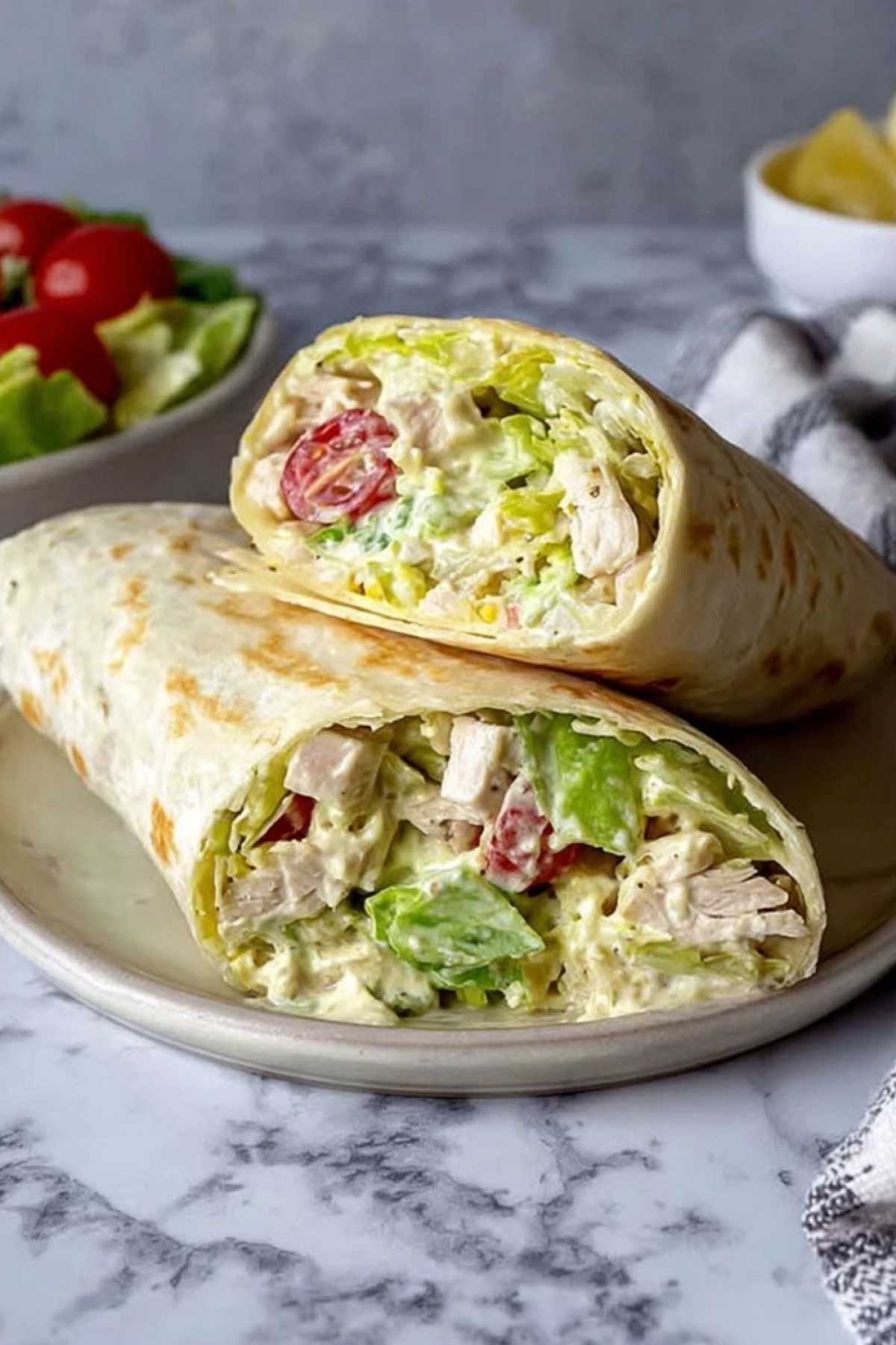 Hähnchen Caesar Salat Wrap 4 Hähnchen Caesar Salat Wrap diagonal geschnitten mit sichtbarer Füllung aus Römersalat und Hähnchen