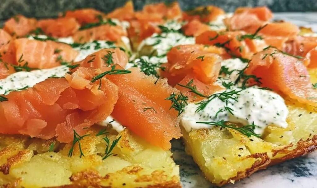 Kartoffelpizza mit geräuchertem Lachs auf Backblech mit frischem Dill garniert