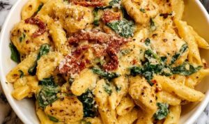 Marry Me Chicken Pasta in großer Pfanne mit cremiger Sauce und frischem Spinat