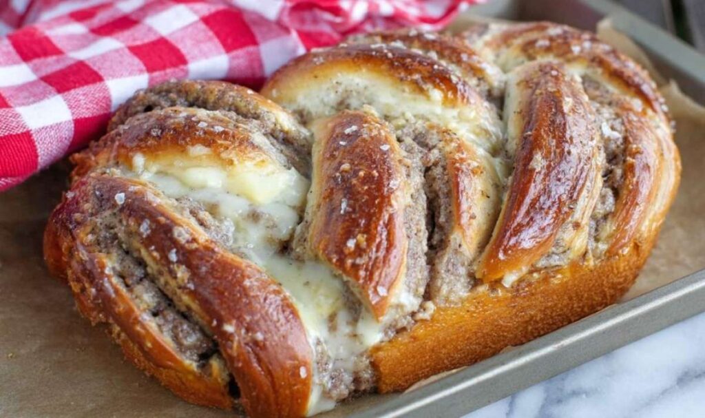 Nusszopf Rezept - Saftig & Traditionell 2 Goldbraun gebackener Nusszopf mit weißem Zuckerguss auf Backpapier