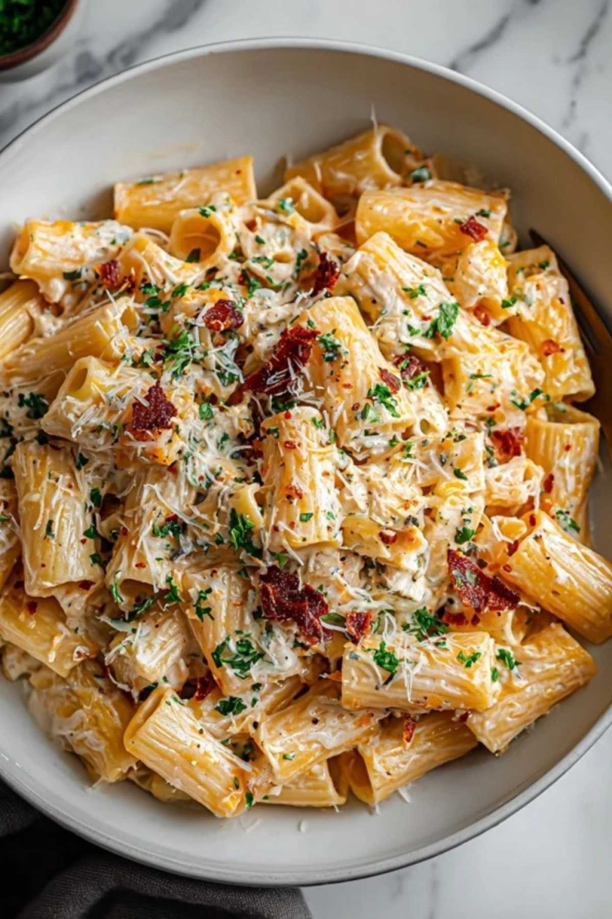 Teller mit Protein-Nudeln mit Hüttenkäse garniert mit Basilikum und Parmesan