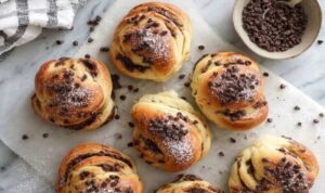 Protein-reiche Schoko-Brötchen Protein-reiche Schoko-Brötchen frisch gebacken auf Backpapier mit geschmolzenen Schokotropfen