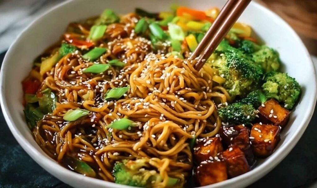 Veganer Teriyaki Noodle Bowl mit knusprigem Tofu, Brokkoli, Möhren und Paprika in glänzender Teriyaki-Sauce