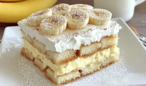 Bananen-Tiramisu in einer Auflaufform mit Bananenscheiben und Schlagsahne als Topping