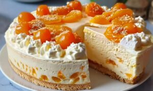 Angeschnittenes Stück Fantakuchen mit Paradiescreme und Mandarinen auf einem Teller