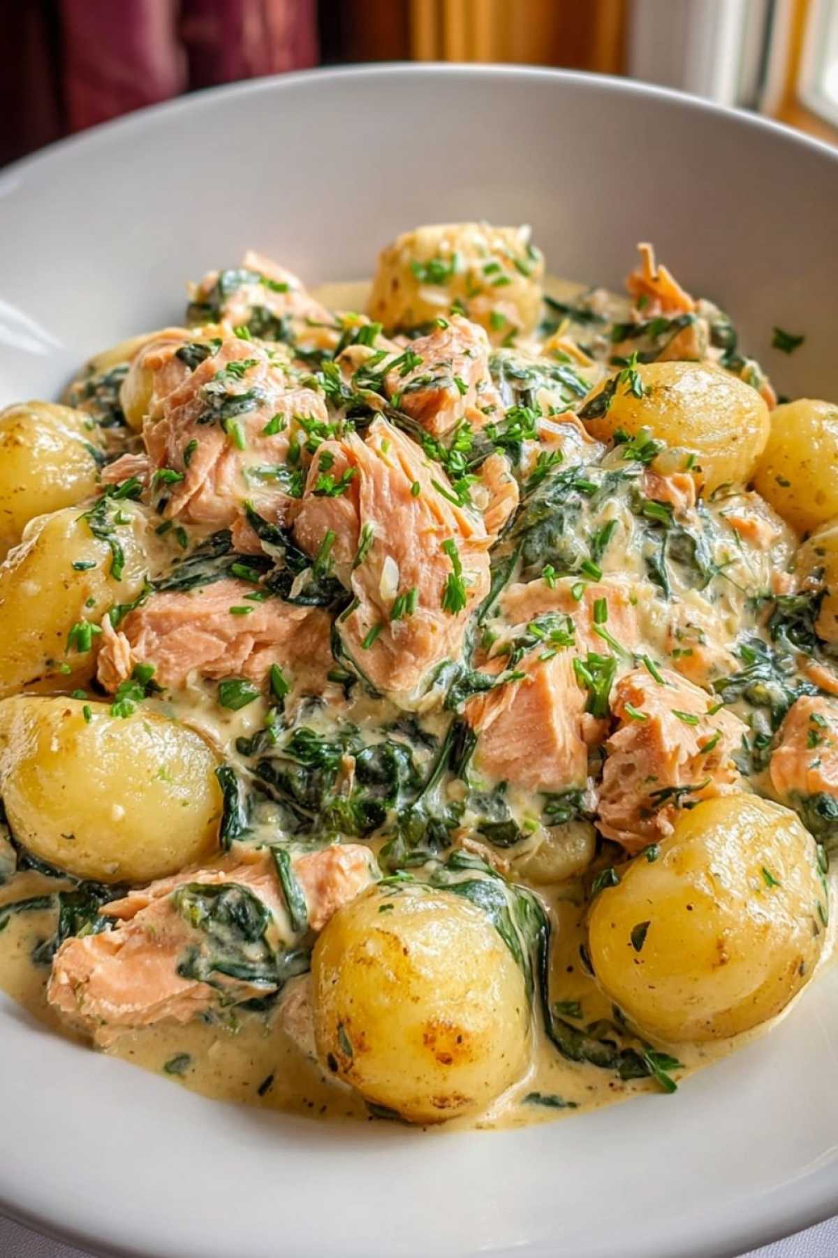 Eine Portion Lachs-Gnocchi mit Zitrone und Petersilie garniert