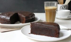 Saftiger Schokokuchen mit glänzender Schokoladenglasur auf einer Tortenplatte